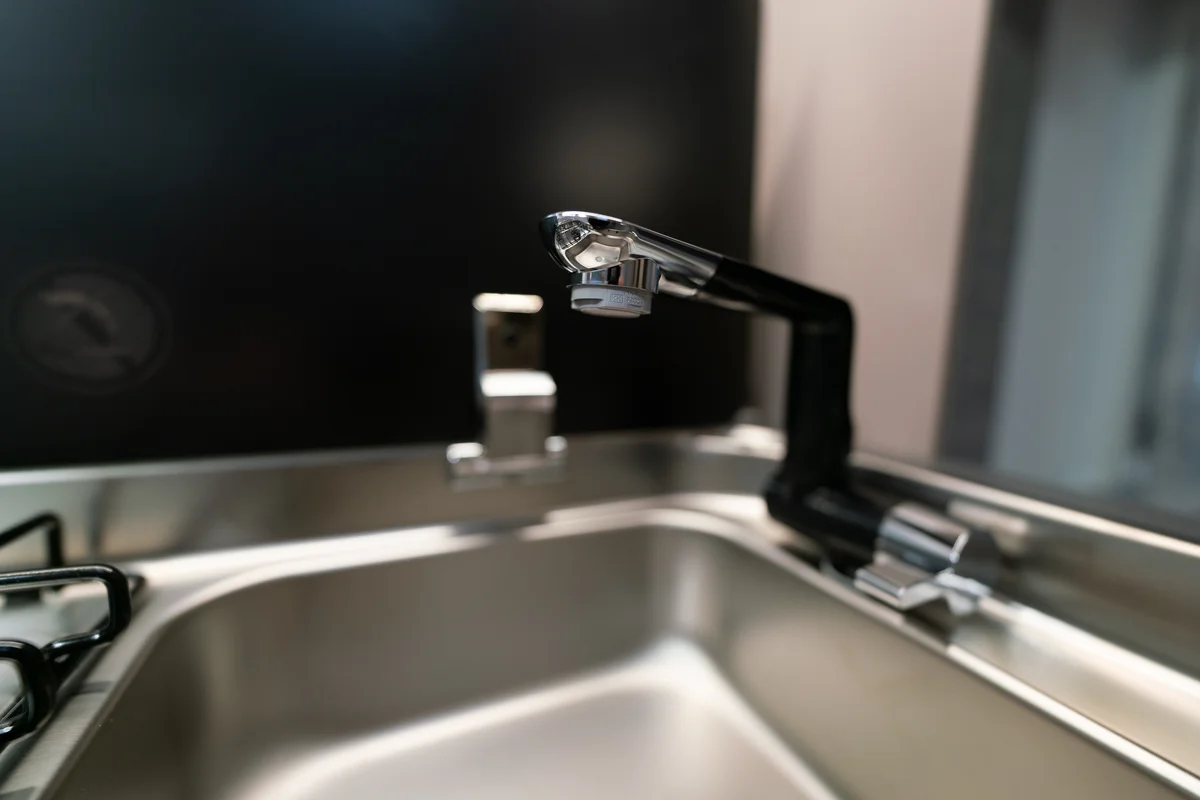 Elegante kraan op aluminium gootsteen in de keuken voor kleine caravans