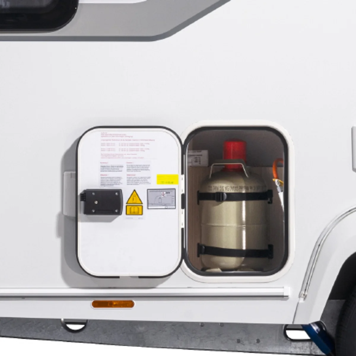 Geöffnete Serviceklappe am NEXT Caravan mit einer gesicherten Gasflasche im beleuchteten Gaskasten-Staufach